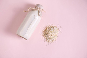 堆白色大米瓶植物基于有机健康的大米牛奶粉红色的表面素食主义者有益健康的乳制品免费的喝