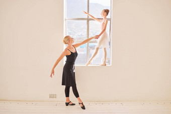 艺术芭蕾舞跳舞老师女孩芭蕾舞女演员练习的姿势窗口工作室有创意的孩子舞者培训教练独奏会音乐会年轻的学生跳舞教练