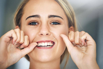 牙线一天肖像有吸引力的年轻的女人用牙线<strong>清洁牙齿牙齿</strong>浴室