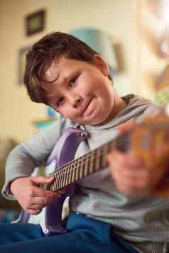 他有才华的年轻的音乐家肖像男孩玩电吉他首页