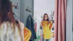 镜子拍摄年轻的夫人选择衣服拟合房间女孩前跳投检查大小长度站相反大镜子