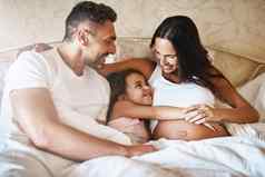 使未出生的婴儿爱快乐女孩说谎床上爸爸怀孕了妈妈。