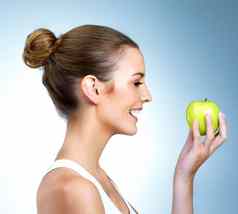 吃健康的使快乐重视健康的年轻的女人摆姿势苹果工作室