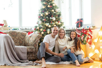 美丽的年轻的家庭享受假期<strong>时间</strong>装修圣诞节树<strong>安排</strong>圣诞节灯有趣的