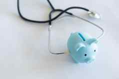 小猪银行听诊器孤立的光蓝色的背景复制空间健康护理金融检查储蓄医疗保险成本概念