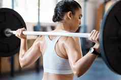 健身动机锻炼女人健身房强烈的举重培训锻炼手臂肌肉强大的女个人教练教练锻炼重杠铃在室内