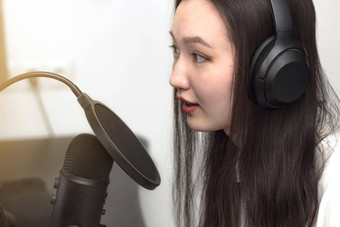 年轻的女人麦克风耳机记录播客工作室专业记录音频特写镜头