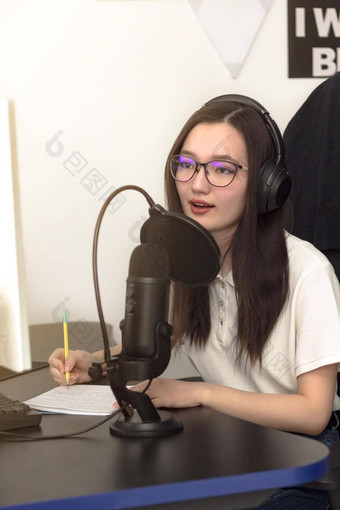 年轻的女人眼镜麦克风耳机记录播客工作室专业记录音频