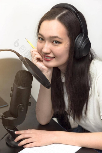 年轻的微笑女人麦克风耳机记录播客工作室专业记录音频