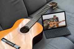 声吉他数字平板电脑沙发上舒适的首页背景在线音乐教训学习玩写作歌曲爱好概念