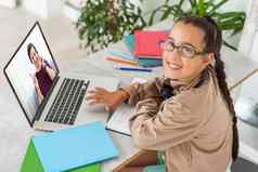 肖像女孩无线耳机移动PC研究在线首页感兴趣快乐学生打字键盘屏幕看网络研讨会在线家庭作业