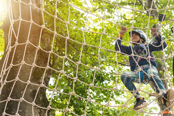 冒险攀爬高线公园孩子们绳子公园肖像可爱的女孩走绳子桥绳子公园