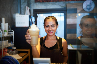 熟练地准备肖像年轻的咖啡师持有冷冻咖啡饮料咖啡商店