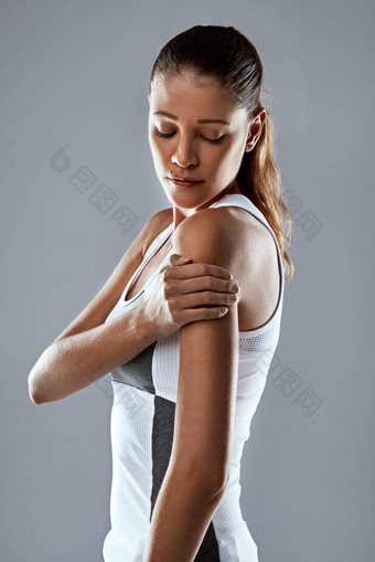 感觉<strong>刚度</strong>手臂工作室拍摄运动年轻的女人持有手臂疼痛灰色背景
