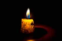 拍摄单孤立的蜡烛燃烧给光周围