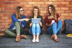 享受免费的校园无线网络微笑女大学学生坐着校园数字平板电脑