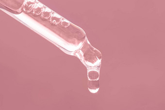 特写镜头粉红色的<strong>下降下降下降</strong>关闭美皮肤护理产品吸管至关重要的石油血清肽透明质酸酸粉红色的背景护理