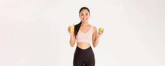 体育运动幸福活跃的生活方式概念肖像健康的适合好看的亚洲女运动员持有橙色汁苹果早....早餐锻炼白色背景