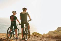 接受邀请骑年轻的夫妇欣赏视图山顶自行车骑