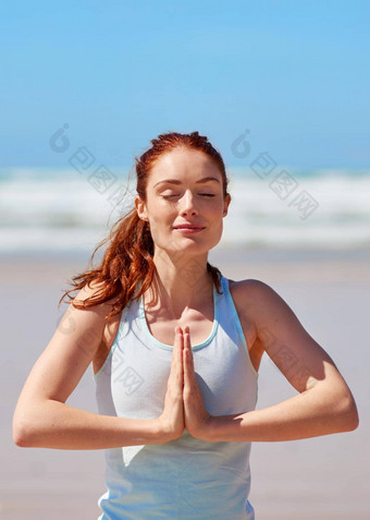 满足静止呼吸年轻的女人练习<strong>瑜伽</strong>例程海滩