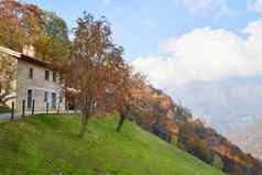 视图房子山一边风景如画的阿尔卑斯山脉秋天景观山山伦巴第意大利旅游冒险