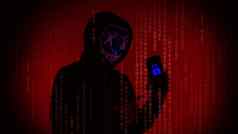 数字安全概念匿名黑客面具持有智能手机黑客攻击