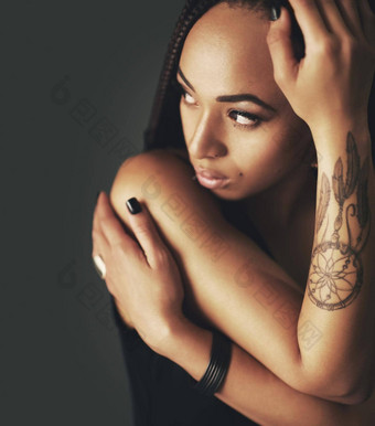 你的纹身真正的工作室拍摄美丽的年轻的女人纹身手臂灰色的背景