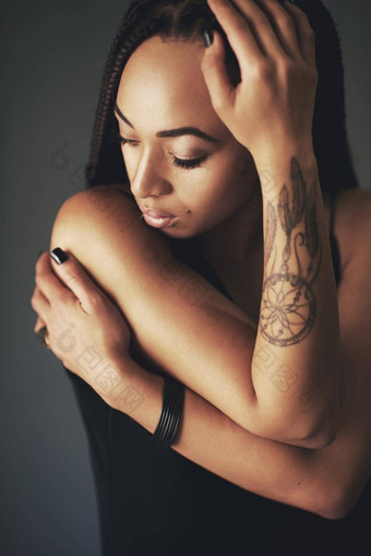 穿情绪袖工作室拍摄美丽的年轻的女人纹身手臂灰色的背景