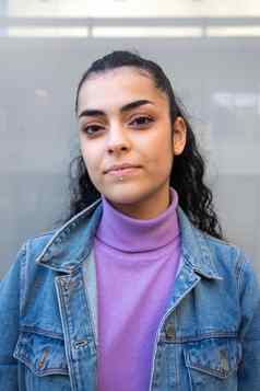 肖像年轻的十几岁的女孩相机穿紫色的高领毛衣牛仔布夹克垂直图像