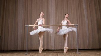 芭蕾舞彩排剧院大厅年轻的芭蕾舞 演员白色芭蕾舞裙子tutus订婚了芭蕾舞执行优雅芭蕾舞锻炼通过attidude站巴利