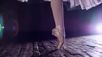 关闭射线关注的焦点阶段剧院大厅芭蕾舞女演员白色芭蕾舞裙子旋转然后尖端鞋执行优雅芭蕾舞锻炼之旅尖端