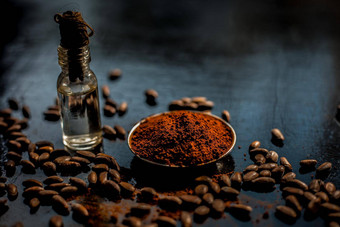 咖啡脸面具抗衰老黑色的彩色的木表面组成咖啡豆子生有机椰子石油小小玻璃瓶