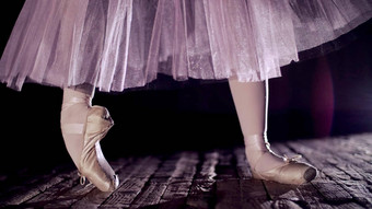 关闭射线关注的焦点阶段剧院大厅芭蕾舞女演员白色芭蕾舞裙子提出了脚趾尖端鞋子执行优雅芭蕾舞锻炼尖端紧张