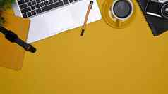 平躺电脑移动PC咖啡杯笔记本智能手表黄色的背景