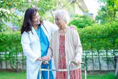 医生亚洲上了年纪的女人残疾病人走沃克公园医疗概念