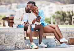 户外公园智能手机夫妇看在线视频内容有趣的模因社会媒体帖子板凳上快乐放松爱男人。女人浏览互联网夏天周末打破