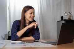 快乐的女人自由职业者工作在线移动PC坐着桌子上首页屏幕