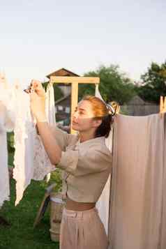 洗衣一天女人挂起亚麻毛巾树院子里村房子