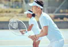 亚洲网球男人。球拍培训实践玩游戏法院集中健身运动员玩有竞争力的双匹配团队保持适合健康的体育俱乐部