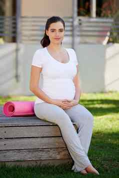 妍瑜伽一天年轻的怀孕了女人坐着瑜伽席