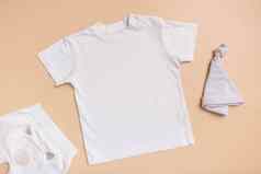 白色婴儿t恤前视图模型标志文本设计米色背景平躺孩子衣服