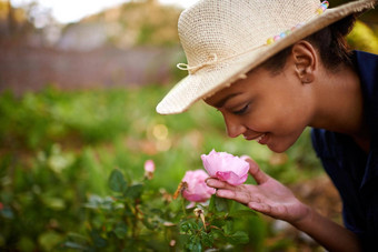 品味美劳动年轻的女人欣赏玫瑰花园