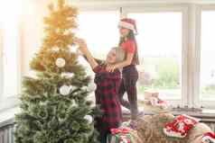 家庭冬天假期人概念快乐妈妈。女儿装修圣诞节树首页