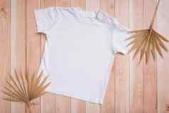 白色婴儿t恤前视图模型标志文本设计木背景平躺孩子衣服