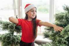 女孩长头发装修绿色树庆祝圣诞节聚会，派对孩子装修圣诞节树首页