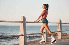 夏天辊滑冰黑色的女人海滩散步健身自由有趣的锻炼爱好培训放松平静阳光自然年轻的滑冰文化很酷的城市女孩海青年