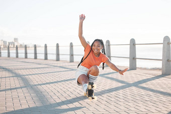 时尚黑色的女人辊滑冰有趣的海滩海海洋砖街迈阿密佛罗里达肖像微笑快乐好玩的学生趋势风格很酷的衣服自由体育特技