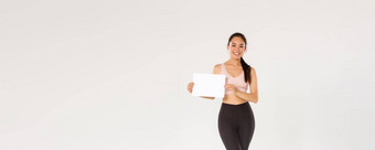 完整的长度微笑好看的亚洲浅黑肤色的女人女运动员女运动员运动服装显示标志空白纸广告健身房会员锻炼设备特殊的价格