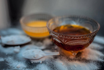 烘焙苏打水脸面具玻璃碗木表面烘焙苏打水粉蜂蜜黑暗嘴唇水平拍摄