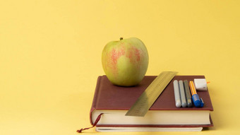 教科书笔铅笔苹果黄色的背景回来学校